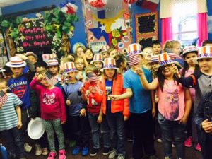 Jennifer Haynie’s second grade students at Everett Elementary wear red, white and blue hats and wave flags while FaceTiming Everett teacher Taylor Bland.  Bland left Wednesday evening to attend the week’s activities in Washington D.C. 